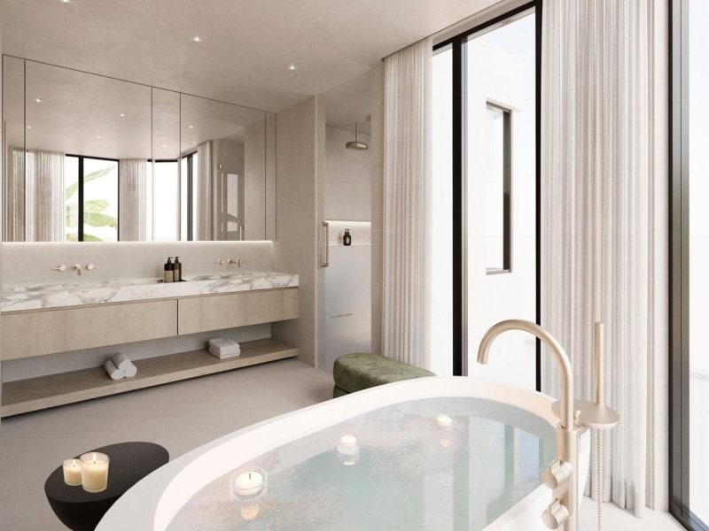 Organic Modern bathroom featuring a sculptural soaking tub, floating double vanity with marble top, and tall sheer drapes with natural light.