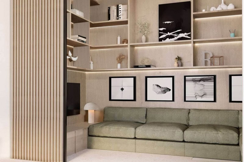 Organic Modern den featuring a green upholstered sofa, light wood built-ins with LED shelf lighting, and integrated media storage.