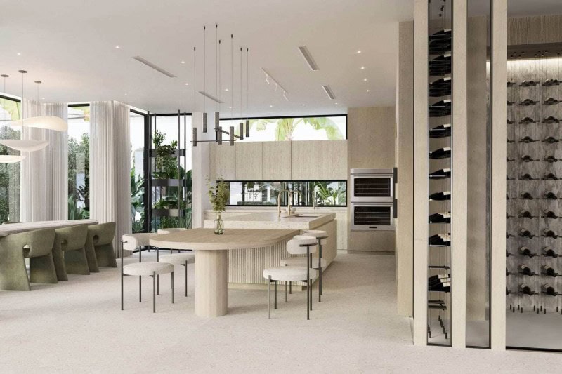 Organic Modern kitchen with textured cabinetry, brass accents, open dining area, and glass-enclosed wine storage in a waterfront Fort Lauderdale home.