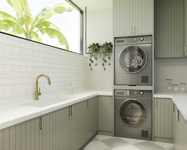 Laundry room with vertical sage cabinetry, large format tile floor, brass faucet, and tropical window view in an Organic Modern home.
