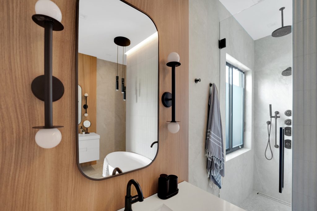 Organic modern bath with custom vanity, matte black details, and full height shower glass
